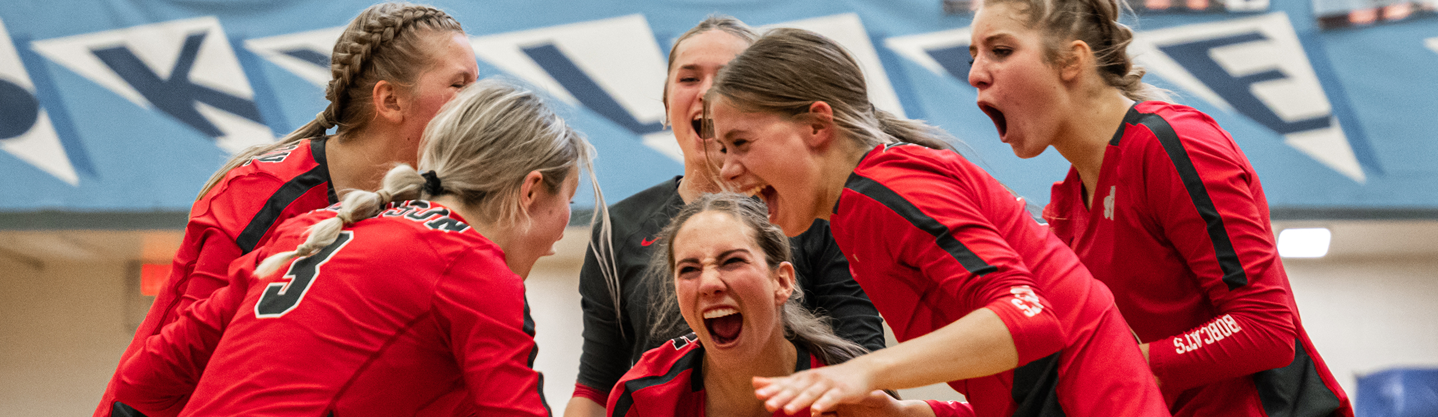 Girl volleyball team celebrates after they score a point.